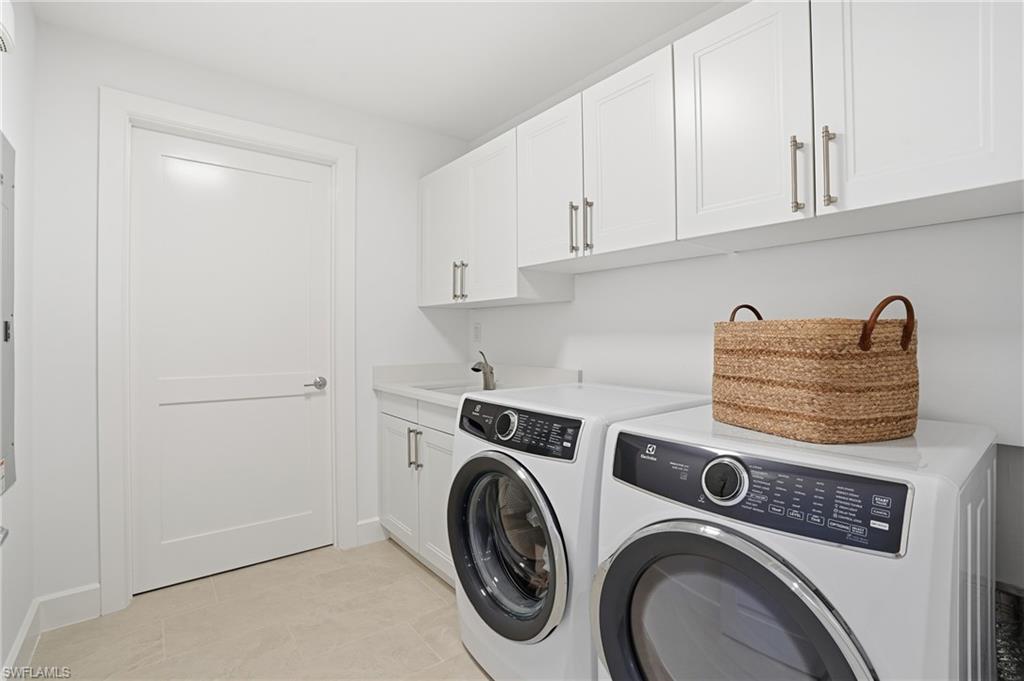 Laundry area featuring separate washer and dryer and cabinet space - Virtually Edited Image