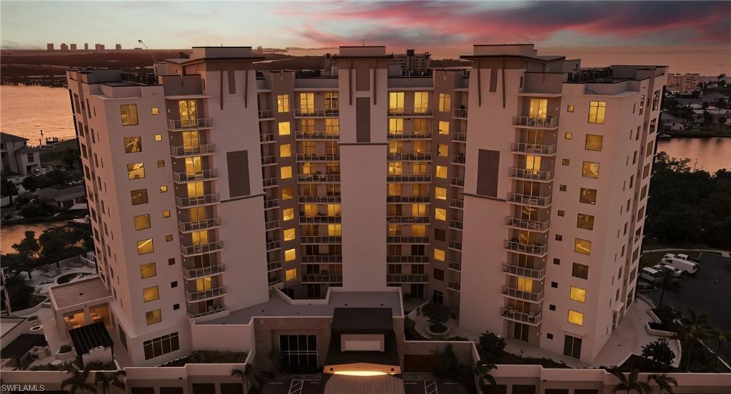 View of apartment building / complex featuring a water view - Virtually Edited Image