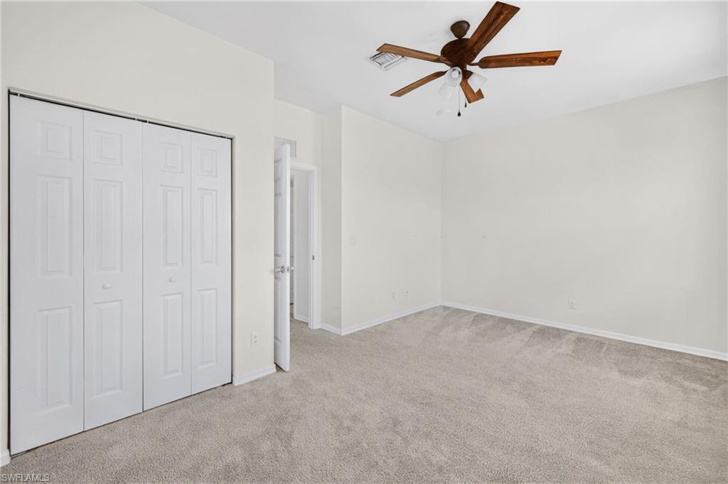 Unfurnished bedroom featuring light carpet, ceiling fan, and a closet
