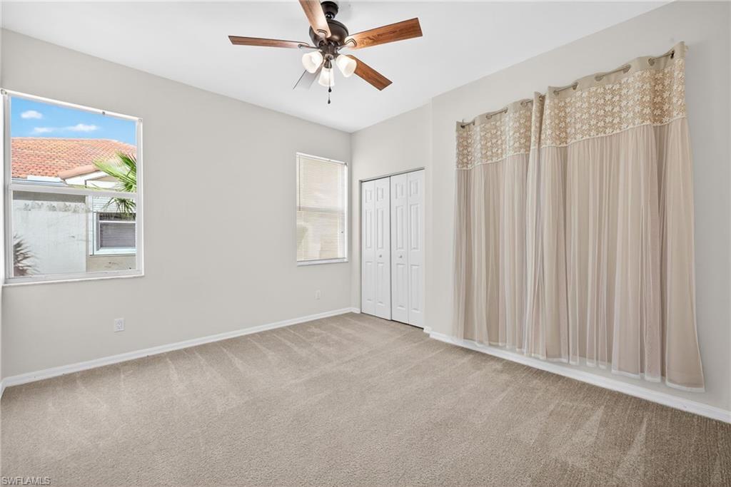 Unfurnished bedroom with carpet, ceiling fan, and a closet