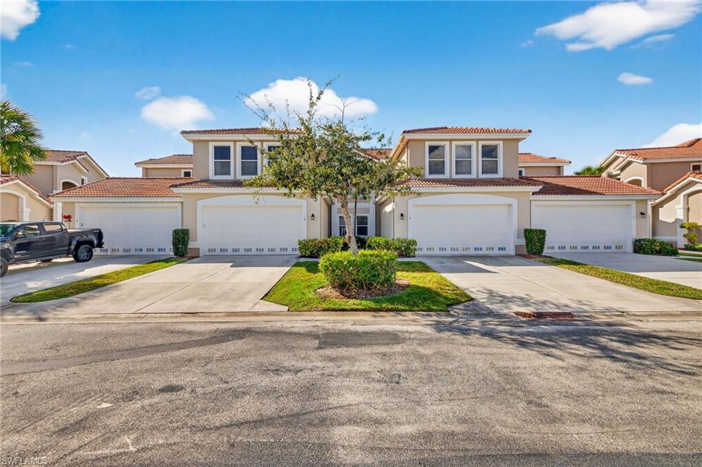 Mediterranean / spanish home with a tiled roof, stucco siding, and driveway