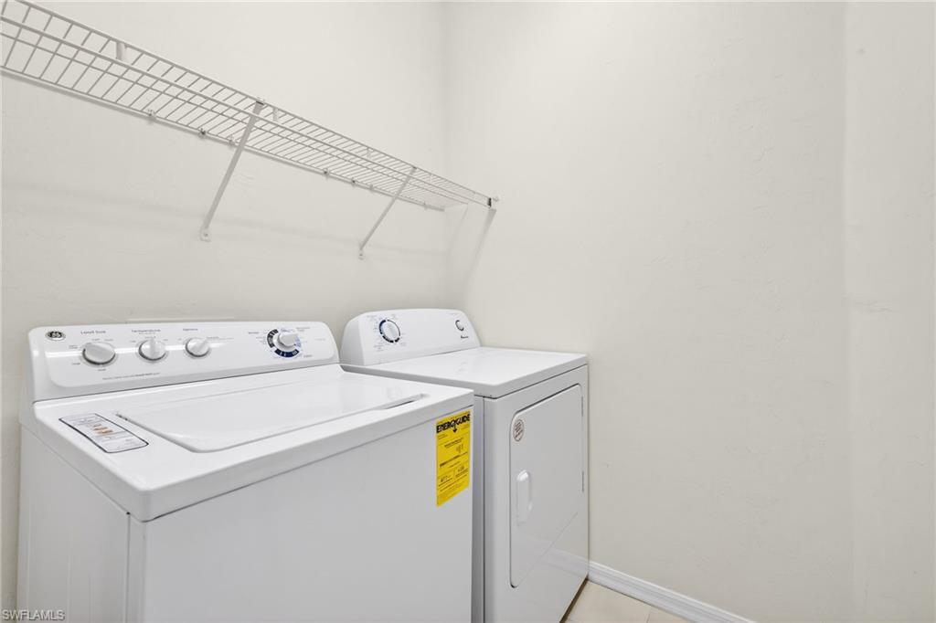Laundry area with washer and clothes dryer and baseboards
