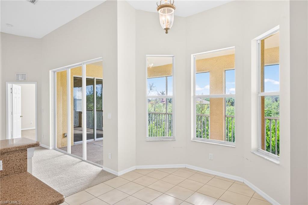 Doorway featuring a chandelier, tile patterned floors, and carpet