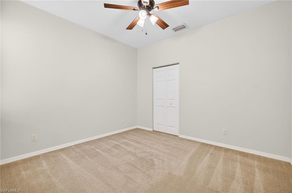 Spare room featuring light carpet and ceiling fan