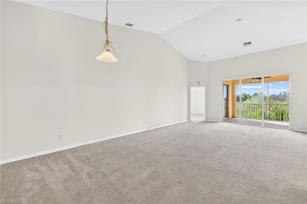 Unfurnished room featuring carpet and high vaulted ceiling