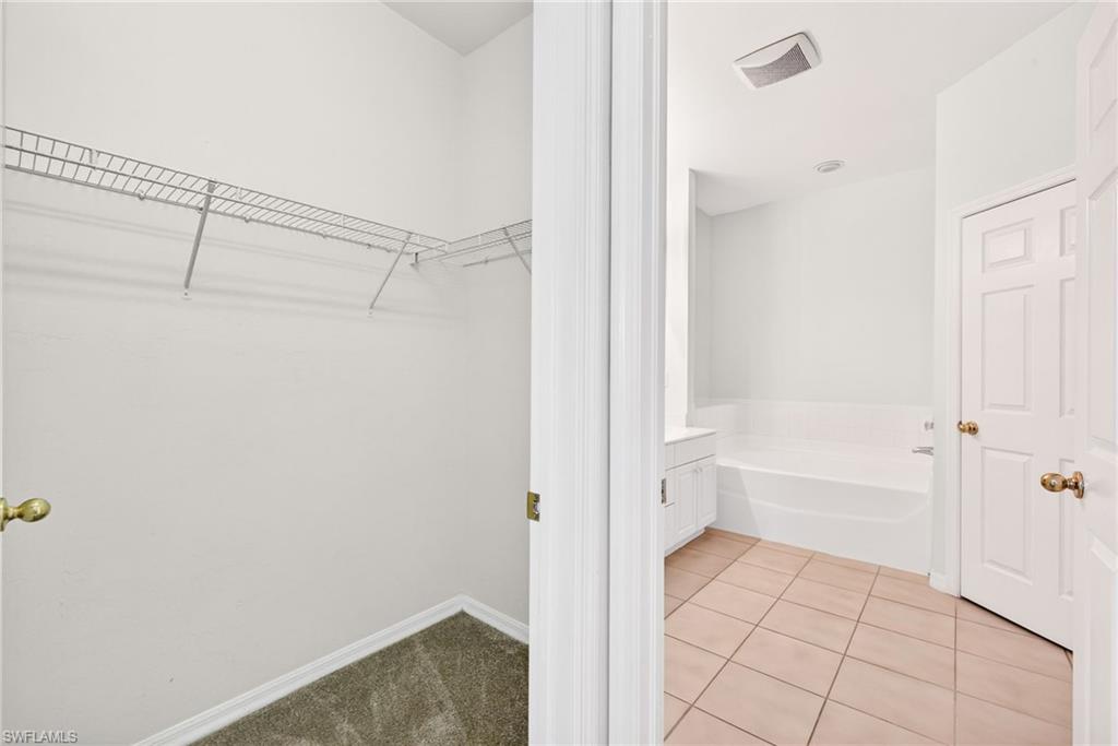 Walk in closet with light tile patterned floors