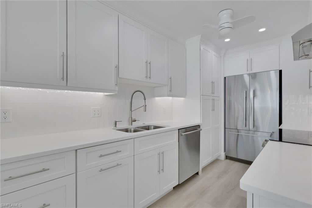 Kitchen with appliances with stainless steel finishes, white cabinetry, tasteful backsplash, light wood-style floors, and recessed lighting