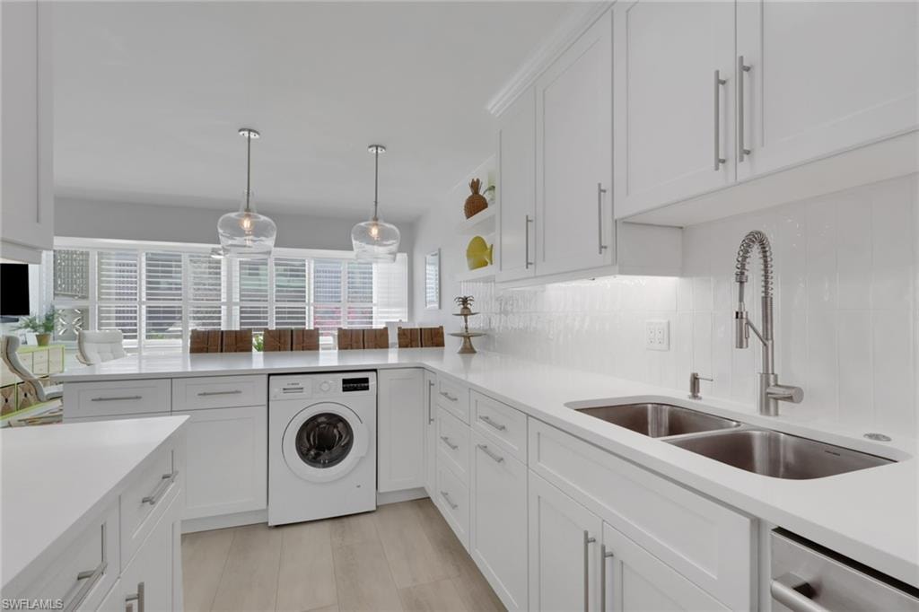 Kitchen featuring white cabinets, washer / clothes dryer, open shelves, and pendant lighting