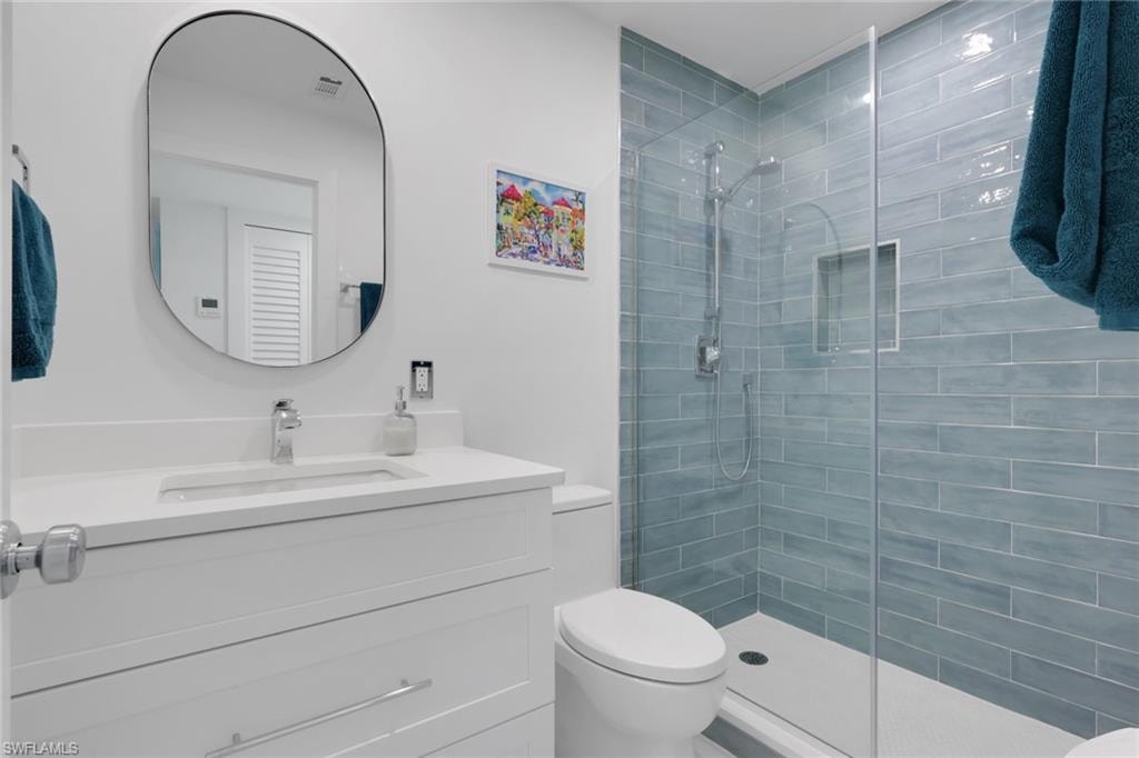 Bathroom featuring a walk in shower and vanity
