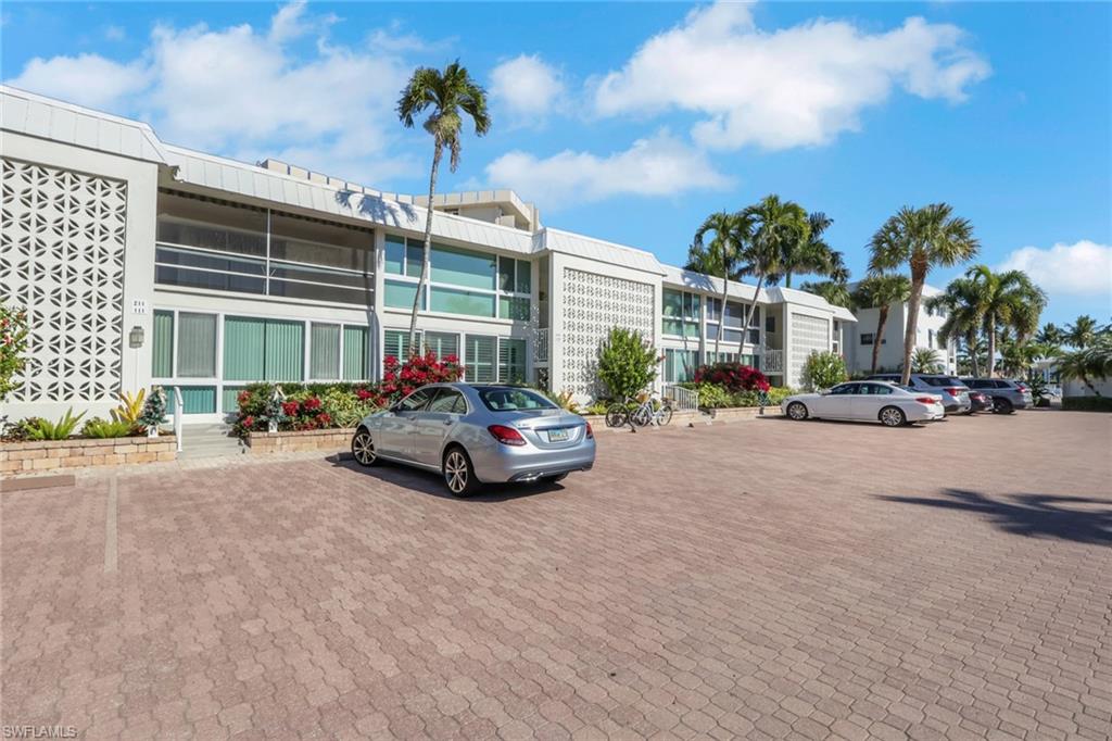 View of apartment building / complex featuring uncovered parking
