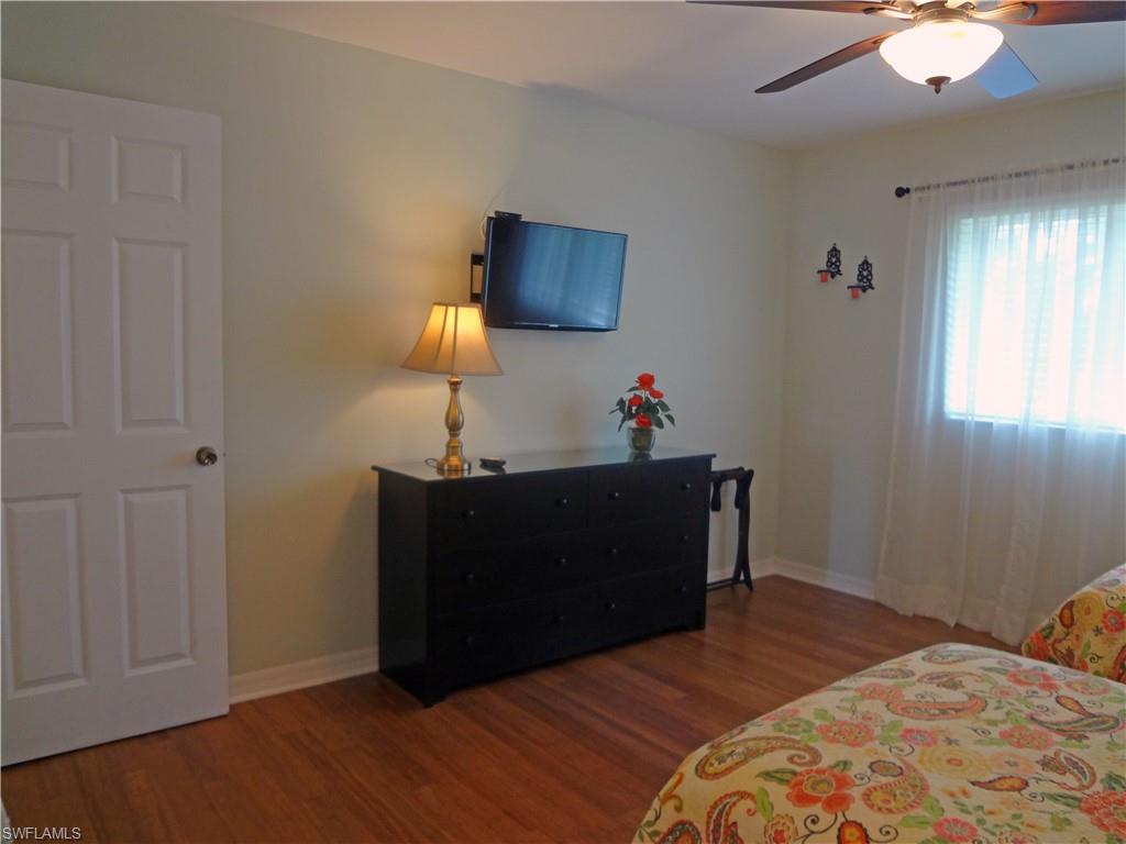 Bedroom with dark wood-style flooring and a ceiling fan
