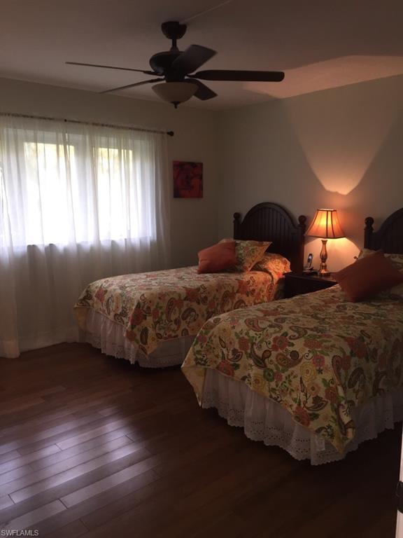 Bedroom with a ceiling fan and dark wood-style floors