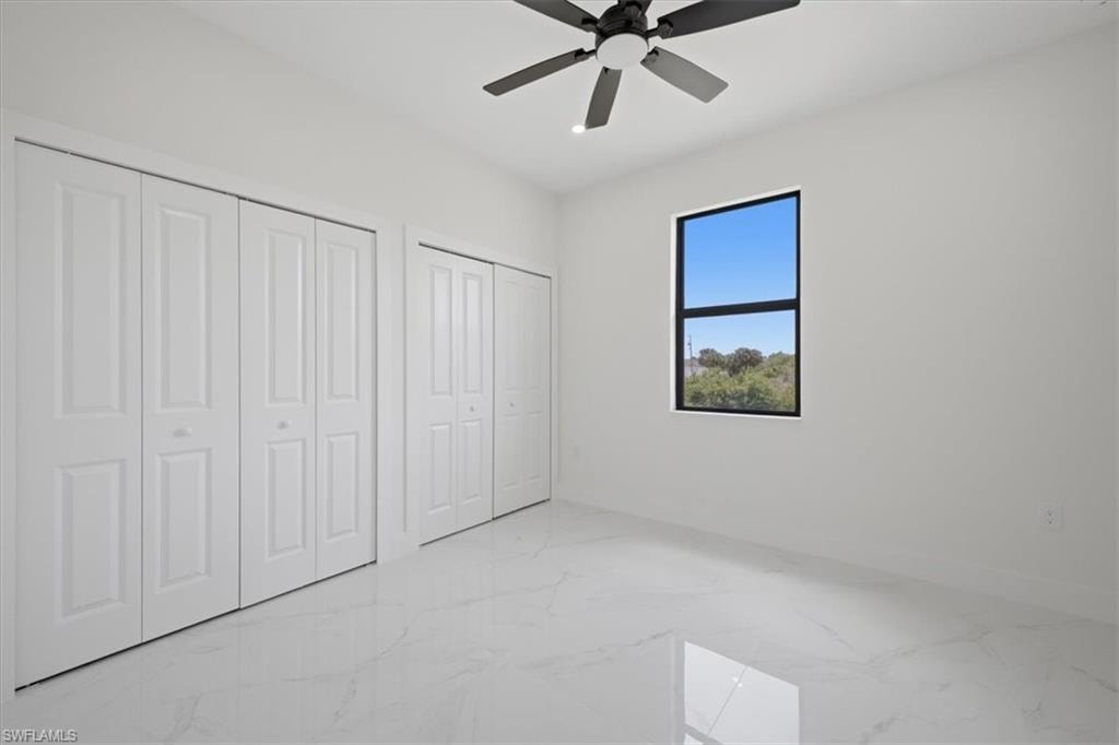 Bright room featuring bifold closet doors, a black-framed window, and a ceiling fan