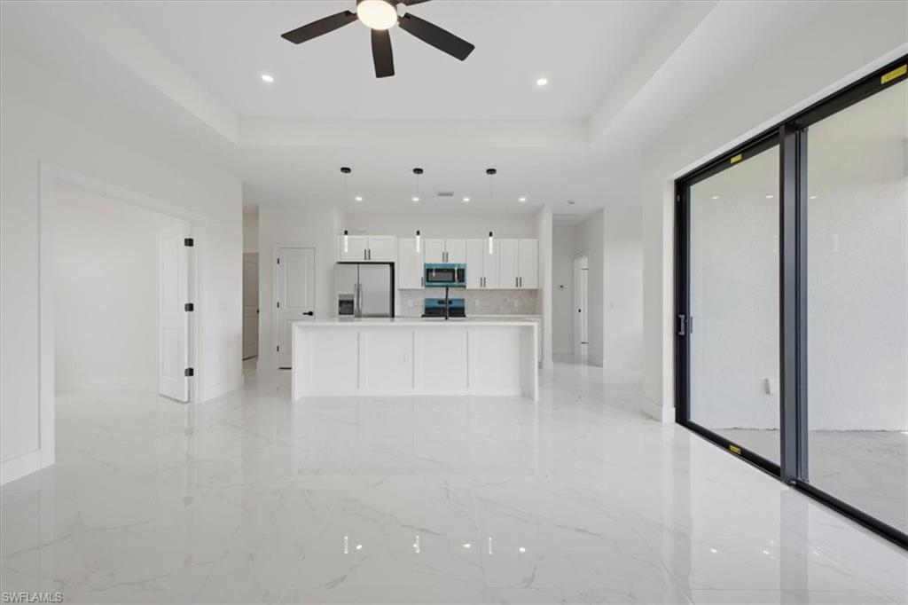 Open-concept living space featuring a contemporary kitchen, wood-finish flooring, and a large sliding glass door