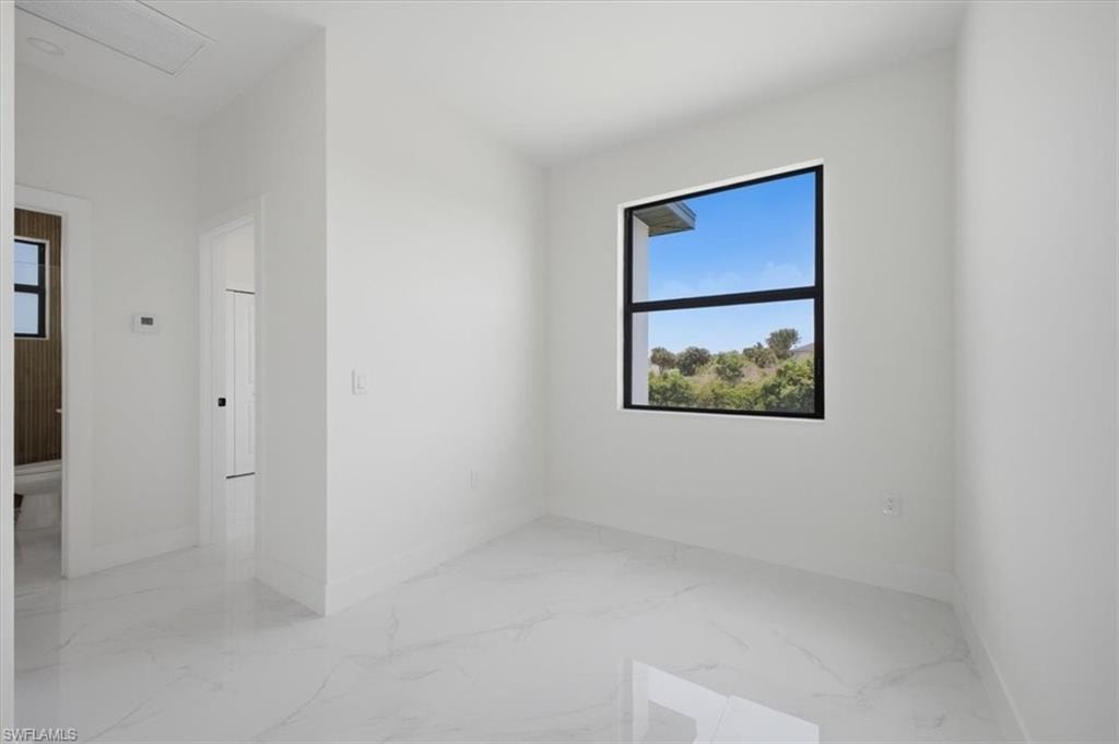 Bright room featuring a large black-framed window, white walls, and white-finish flooring