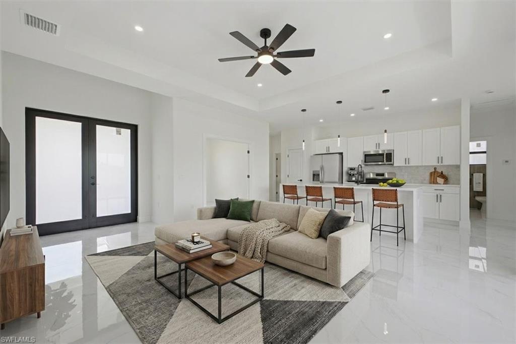 Open-concept living area featuring high ceilings, recessed lighting, and polished tile flooring