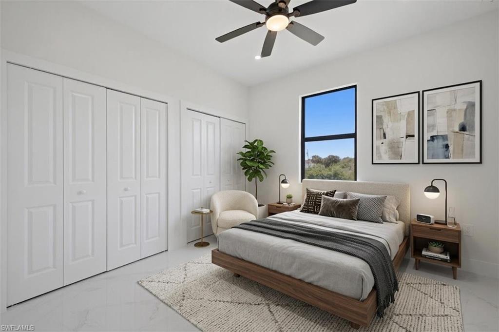 Room featuring a dark-framed window, white walls, and a ceiling fan with integrated lighting