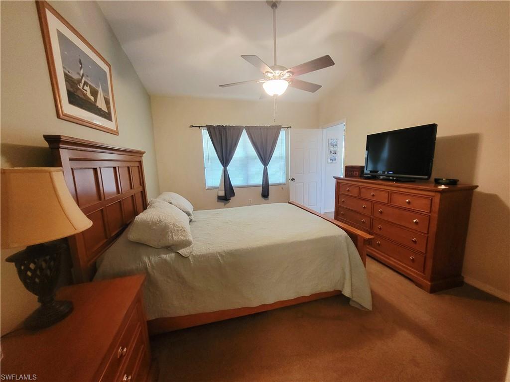 Bedroom featuring vaulted ceiling, carpet floors, and ceiling fan