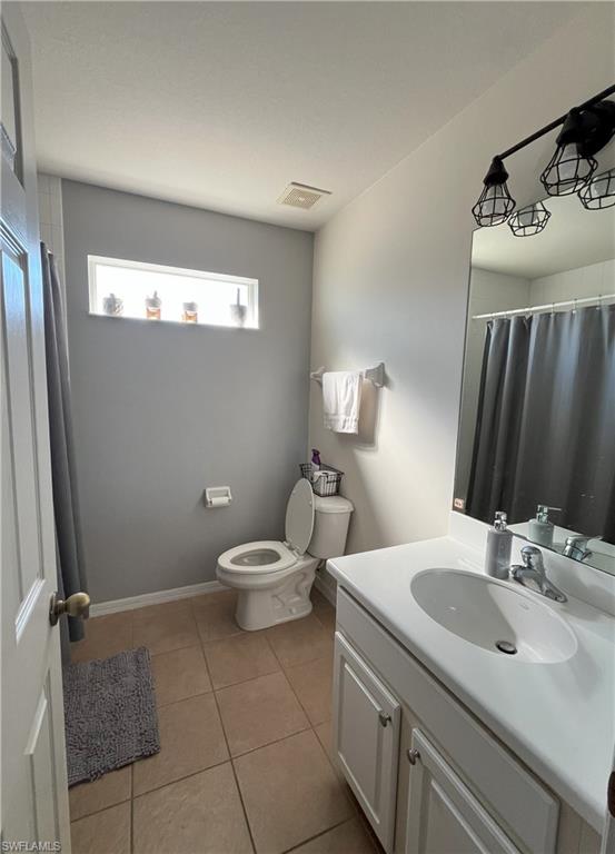 Bathroom featuring light tile patterned flooring, vanity, and a shower with curtain