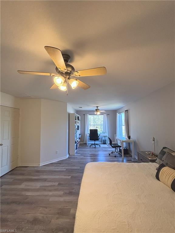 Bedroom with an office area, wood finished floors, and ceiling fan