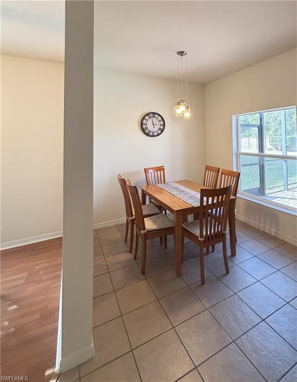Dining space with baseboards and a chandelier