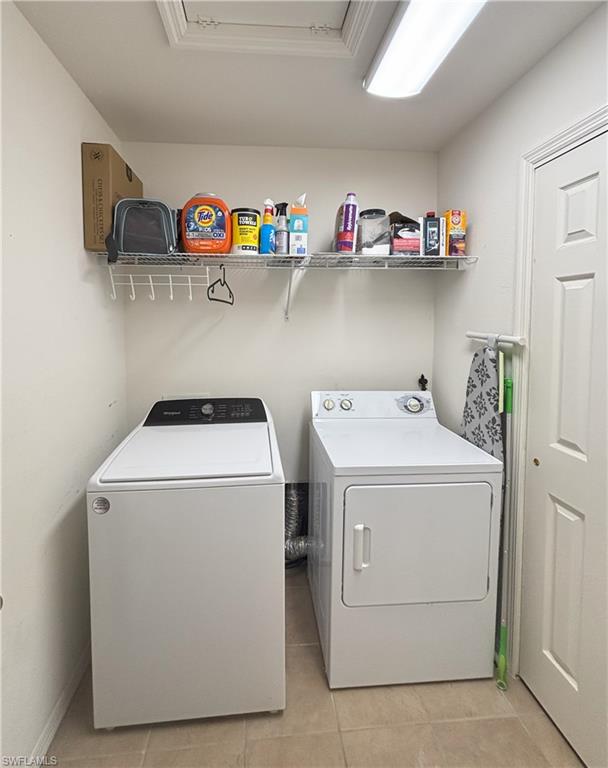 Laundry area featuring light tile patterned floors and washer and dryer