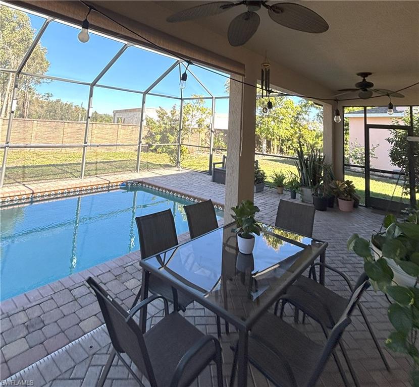 View of patio / terrace with a lanai, a sunroom, an outdoor pool, and a ceiling fan