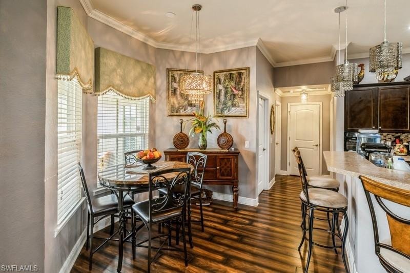 Dining space featuring dark wood-style floors and ornamental molding