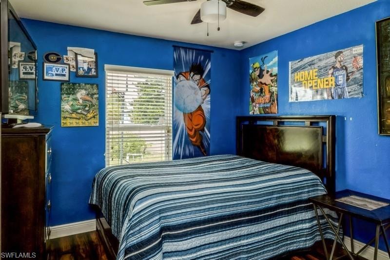 Bedroom with a ceiling fan and dark wood-style flooring