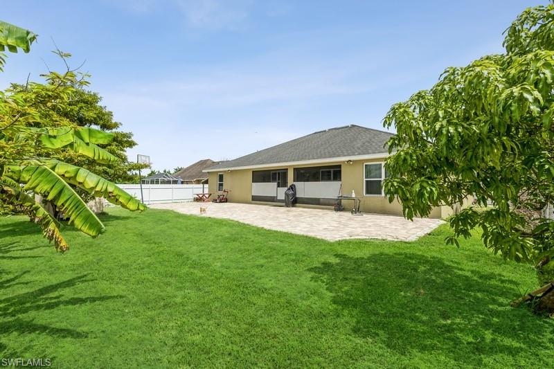 Back of property featuring stucco siding, a patio, a fenced backyard, and a shingled roof