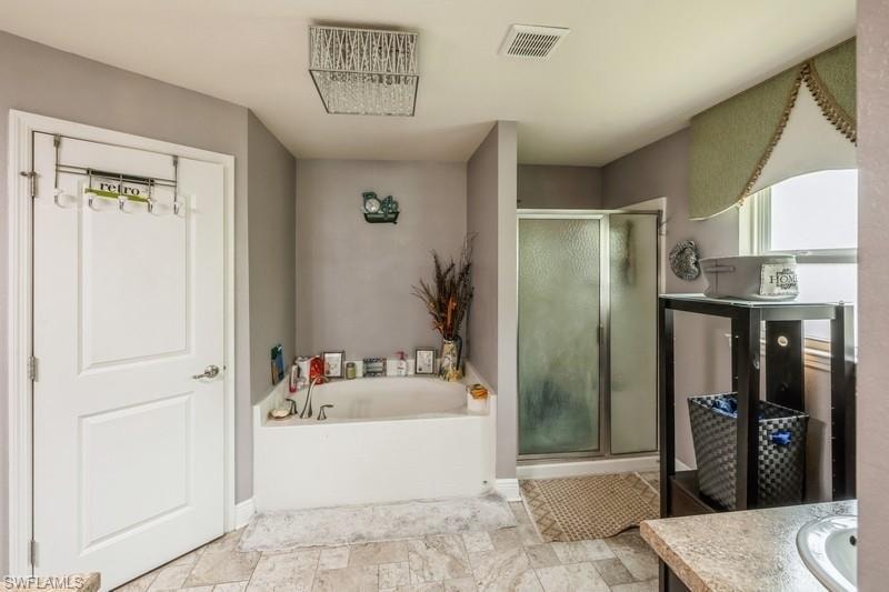 Full bath with vanity, a stall shower, and a garden tub