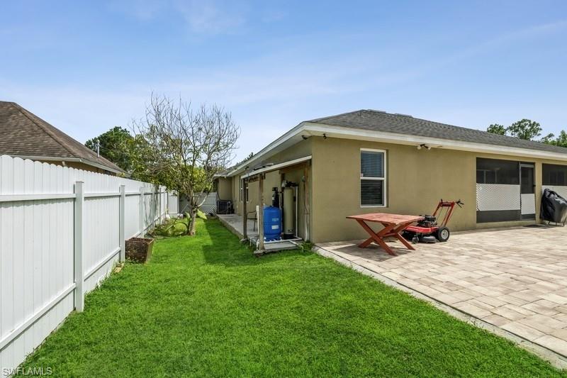 Back of property featuring a fenced backyard, stucco siding, a sunroom, and a shingled roof