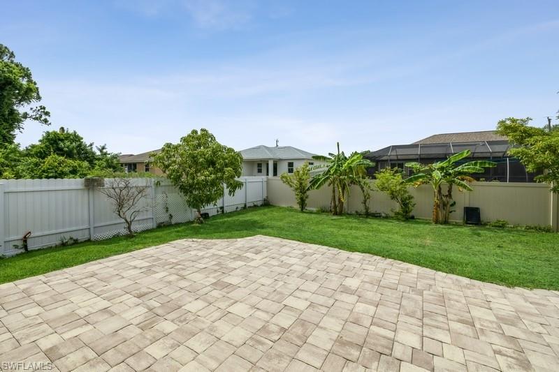 Fenced backyard featuring a lanai