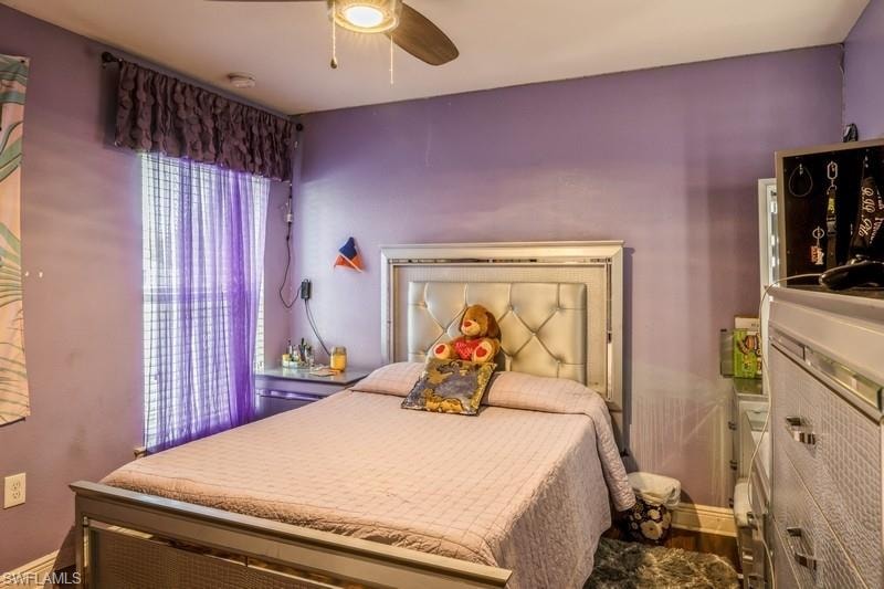 Bedroom featuring ceiling fan and baseboards