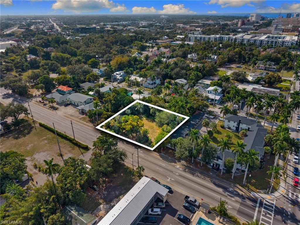 Aerial view of property and surrounding area featuring property boundaries highlighted and a tree filled landscape