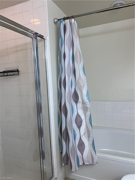 Full bathroom featuring a tile shower and a tub to relax in