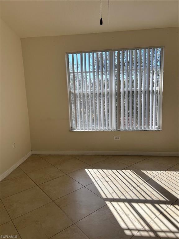 Tiled empty room featuring baseboards