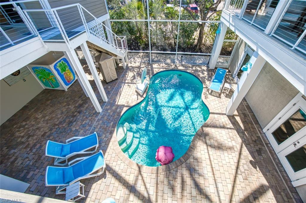 Swimming pool featuring french doors, a patio area, a sunroom, a lanai, and a balcony
