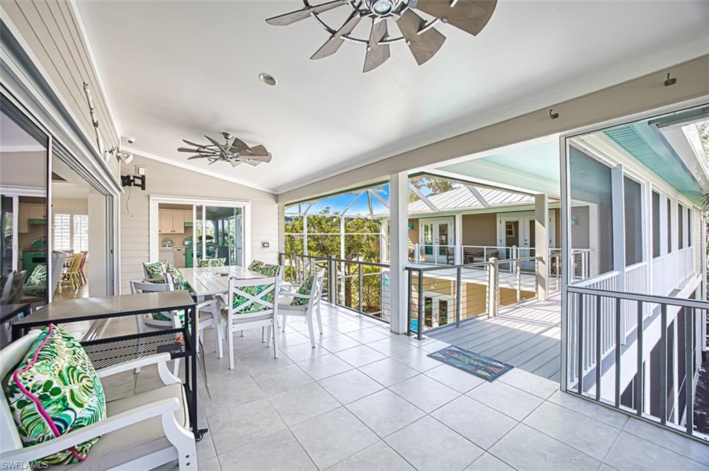 Sunroom featuring an outdoor kitchen, ceiling fan, vaulted ceiling, and outdoor dining area