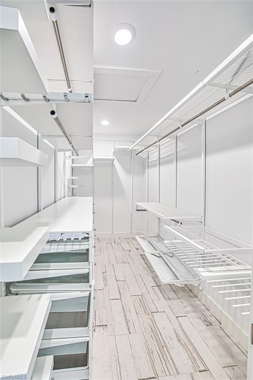 Bathroom featuring a stall shower, recessed lighting, and wood finish floors