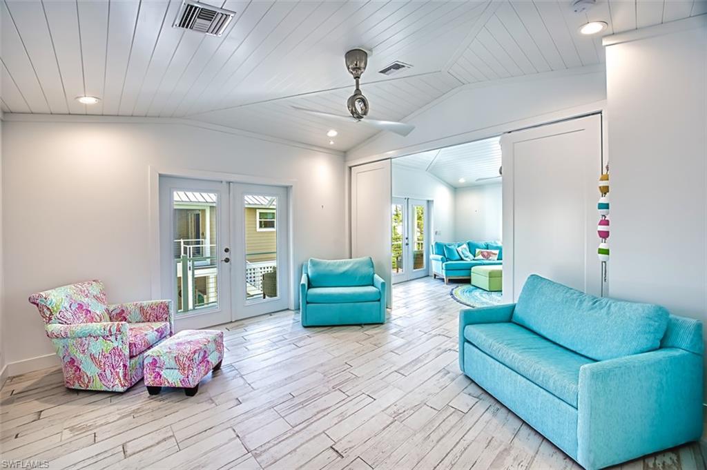 Sitting room with french doors, light wood-style floors, vaulted ceiling, and wood ceiling