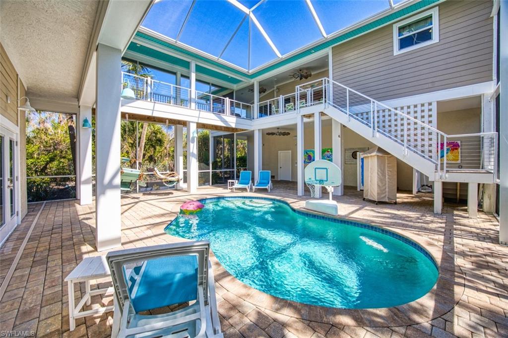 Outdoor pool with a sunroom, glass enclosure, a patio area, and stairway