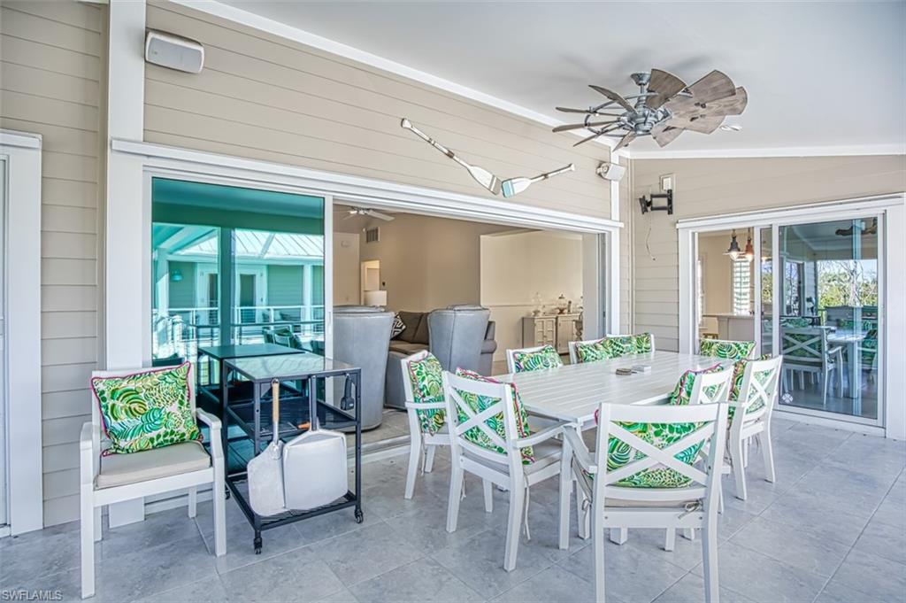 Sunroom featuring a ceiling fan, french doors, exterior kitchen, and healthy amount of natural light