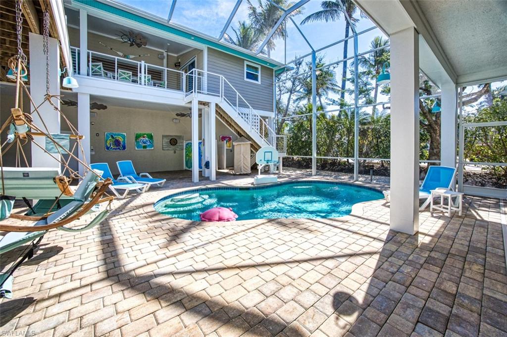 View of patio / terrace featuring stairway, a ceiling fan, and an outdoor pool