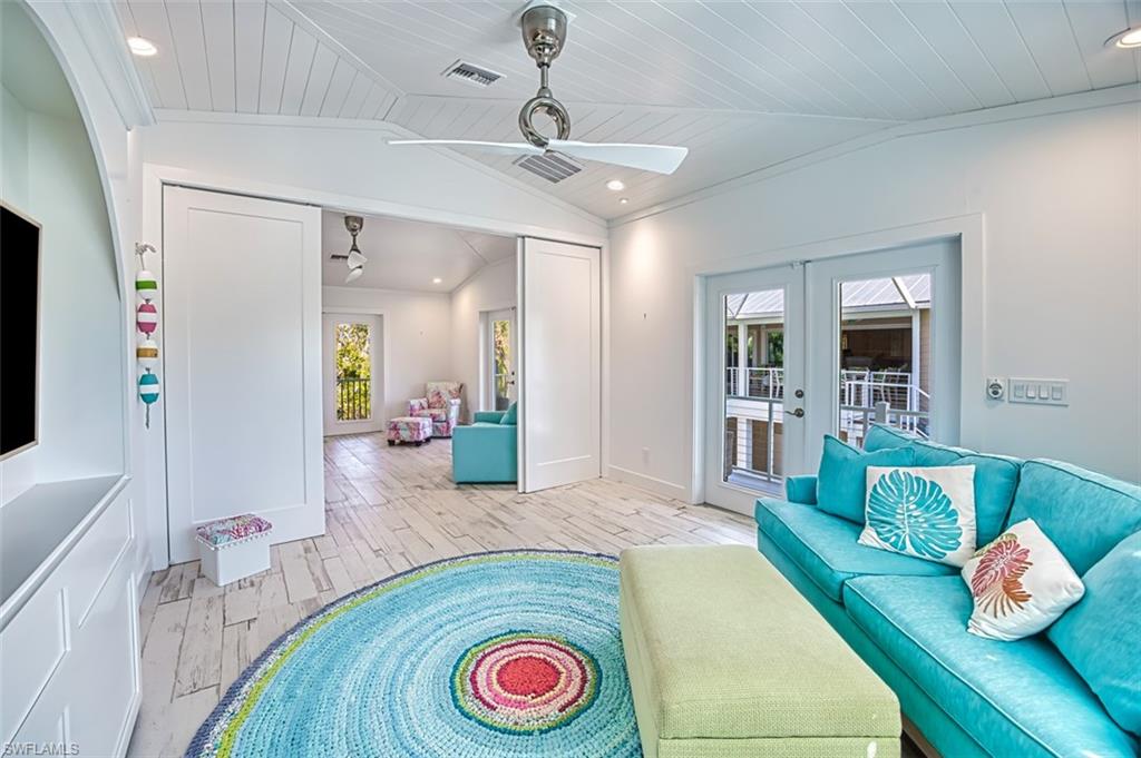 Sitting room featuring light wood finished floors, ornamental molding, recessed lighting, lofted ceiling, and ceiling fan