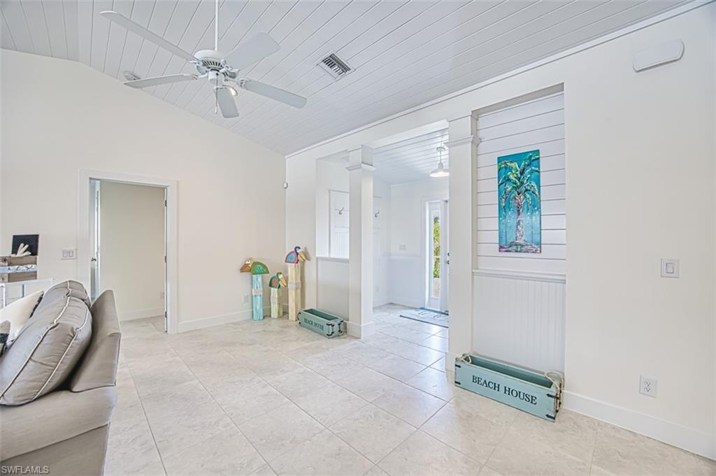 Tiled foyer featuring ornate columns, wood ceiling, a ceiling fan, and lofted ceiling