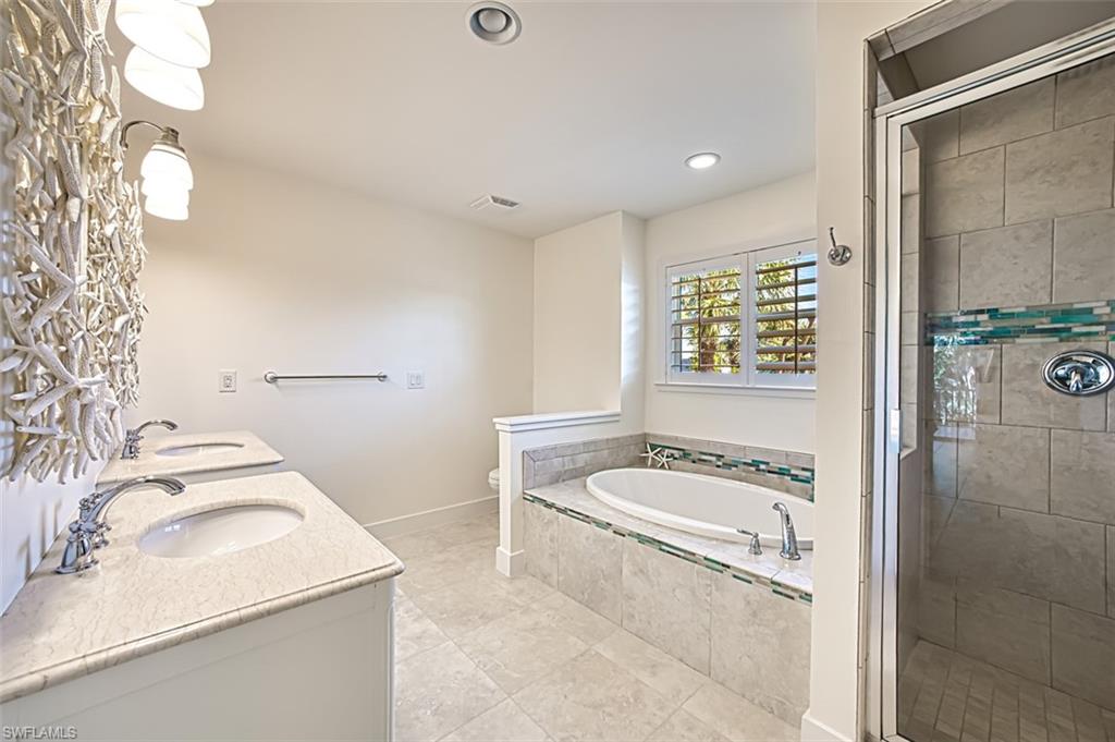 Bedroom featuring vaulted ceiling, access to outside, ceiling fan, multiple windows, and light tile patterned floors