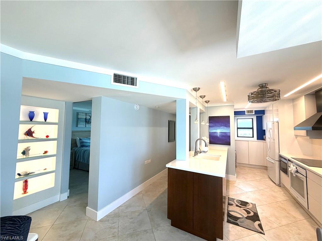 Spacious open-concept living area featuring light-filled interiors with expansive glass sliding doors opening to oceanfront balcony access