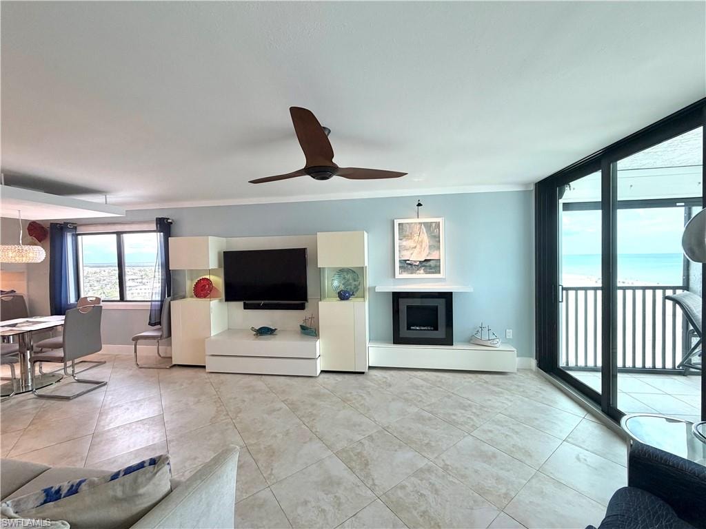 Open-concept living area featuring polished concrete flooring, recessed ceiling lighting, and expansive windows with black-framed glass doors providing natural illumination