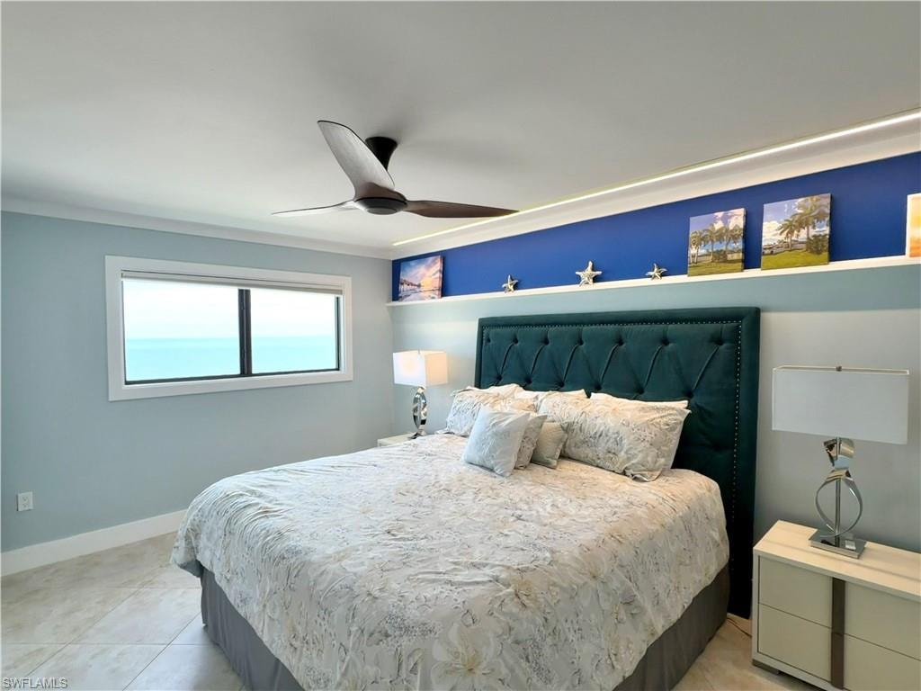 Integrated white cabinetry with sleek handles, overhead ceiling fan, and a window offering natural light and power blind.